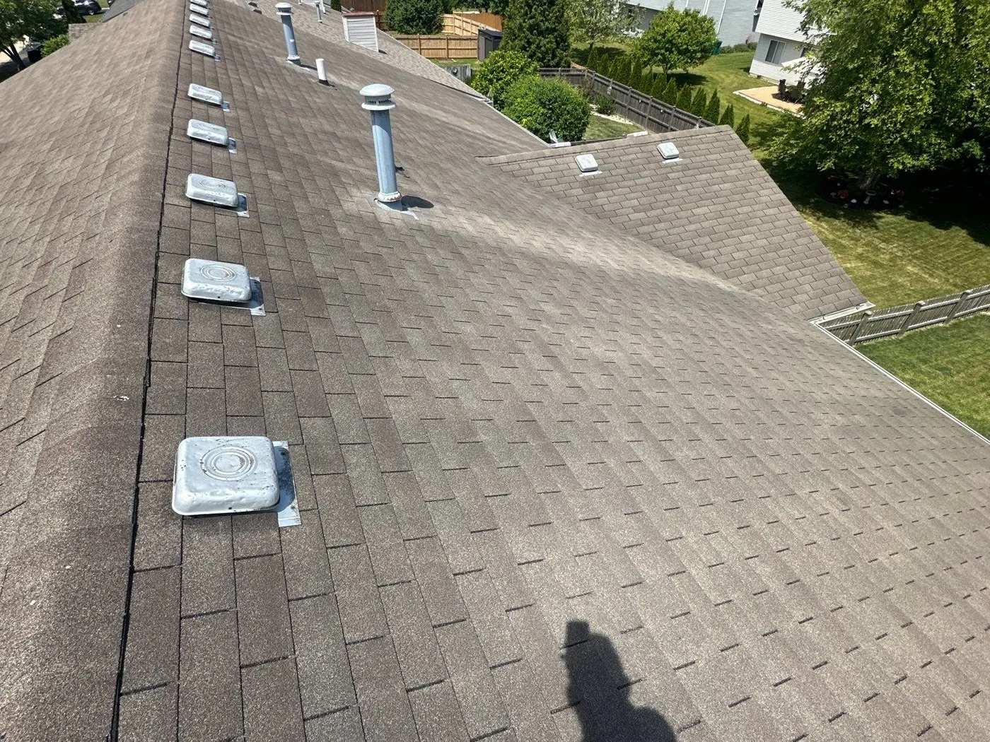 The Carr's Joliet roof with aging shingles and a row of old box vents before replacement