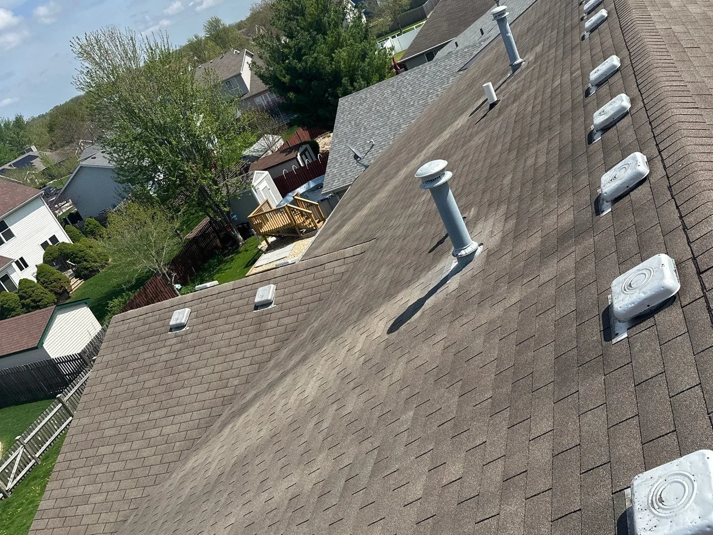 The Nicholson's Joliet roof with worn shingles and aged box vents before replacement