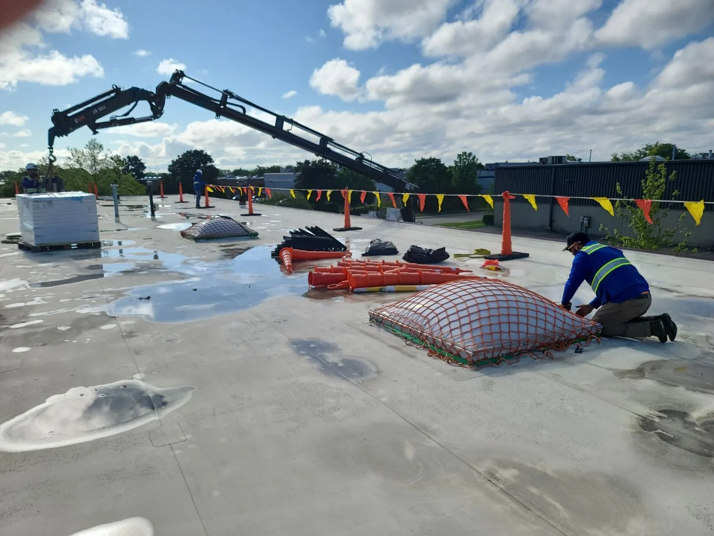 Crew member preparing rooftop equipment during commercial roof replacement project