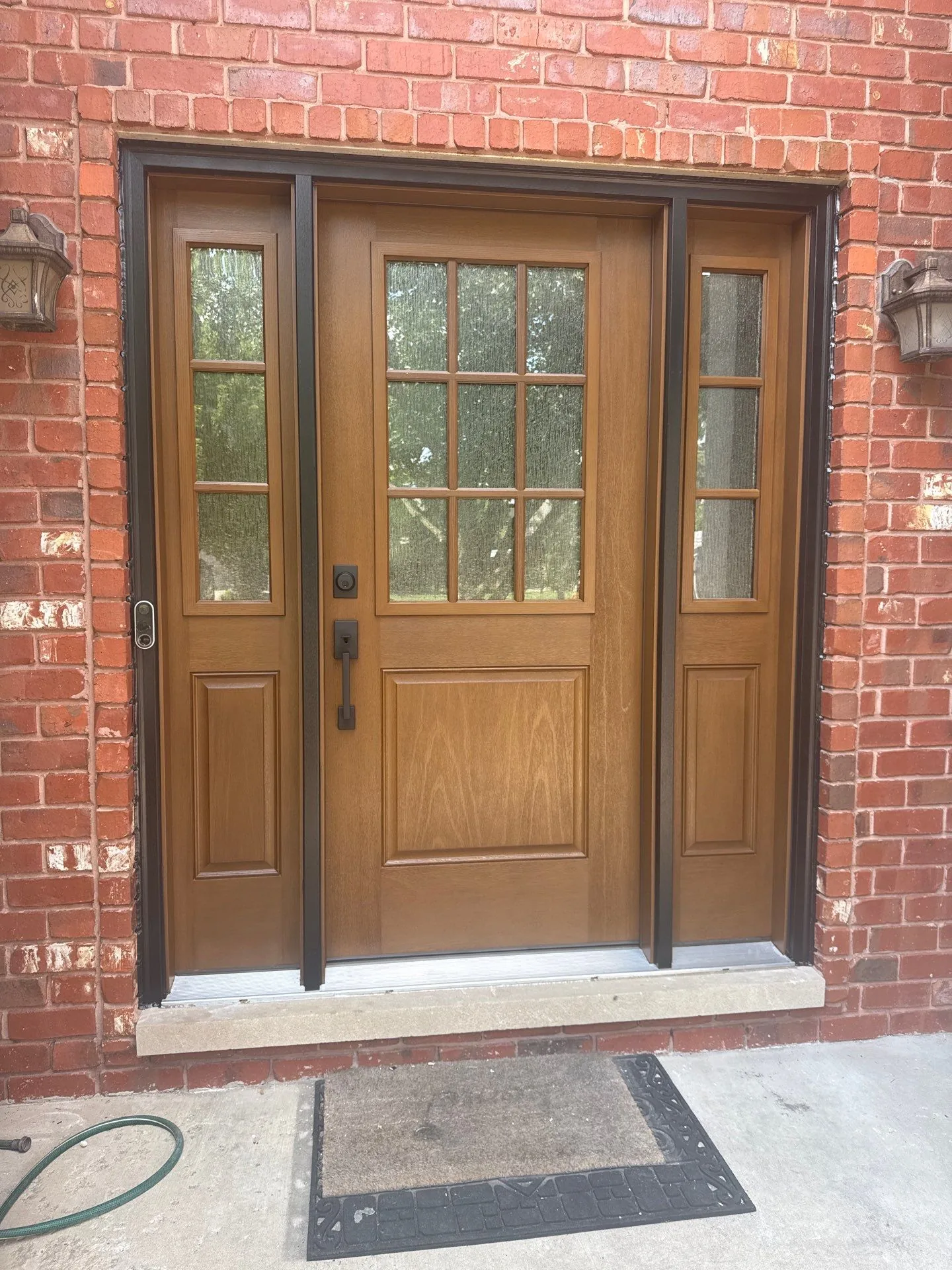 New wood-tone fiberglass entry door installed by Americanstruction