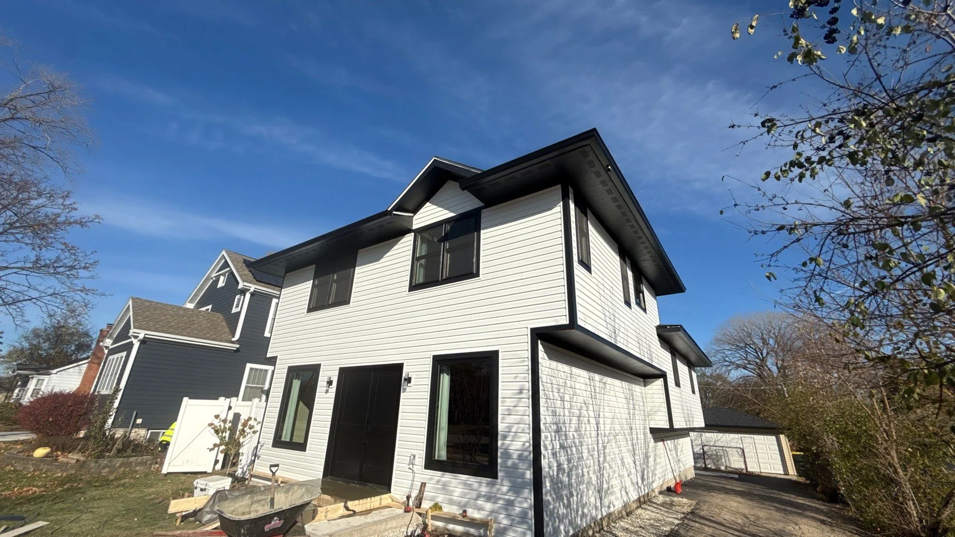 Same Westmont home with new white siding and black-framed windows after the project