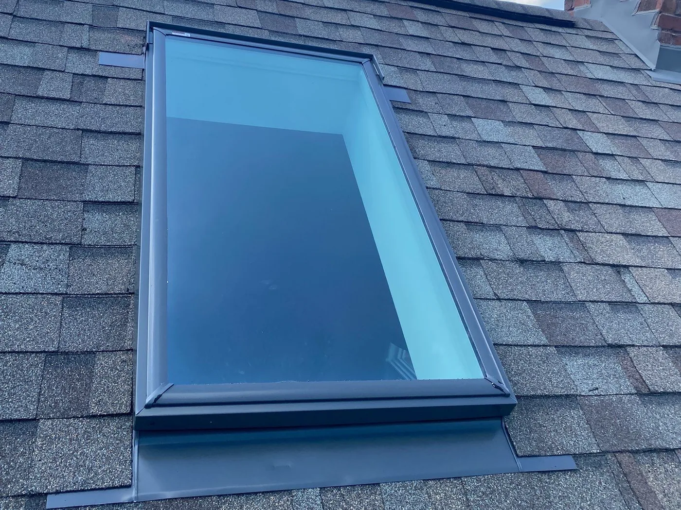 New VELUX skylight with clean step and apron flashing set into new shingles on a Mokena home